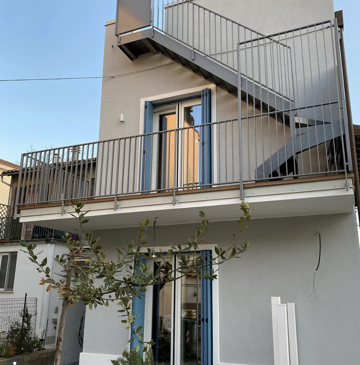 Balcone e scala esterna ristrutturati da FAR Costruzioni Edili, luce calda al tramonto